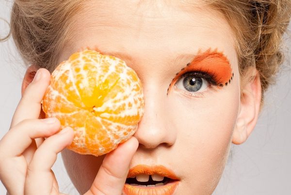Image of women holding peeled orange showing the latest eyebrow trends