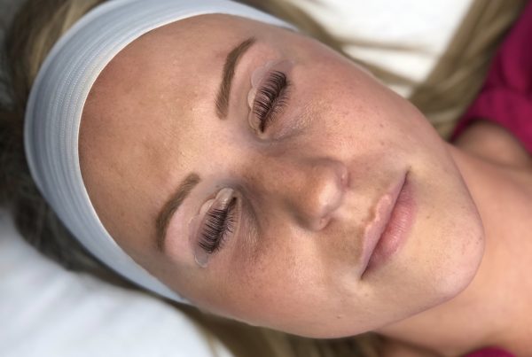 Woman's face getting lash lift service to create longer looking lashes